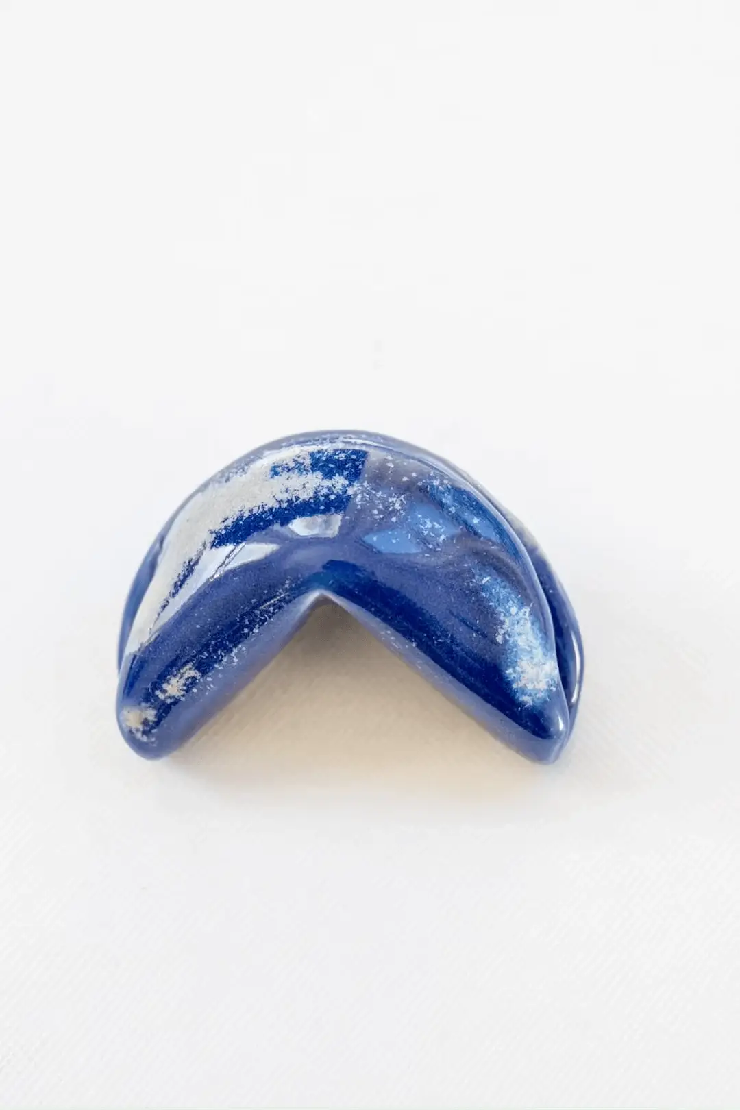 Ceramic fortune cookie with a message from 800 unique fortunes waiting for you on each tap with a phone.